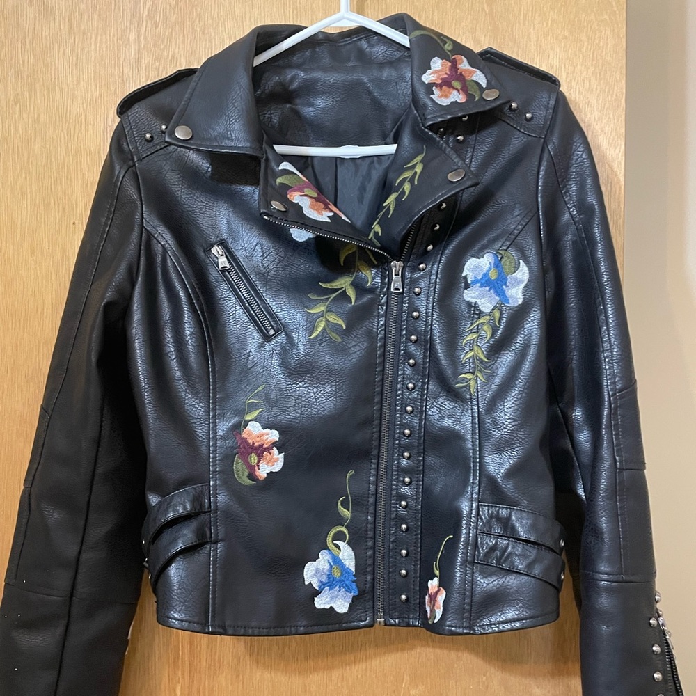 Floral embroidery, stud accents, buckles on side, faux leather, zipper on arms.